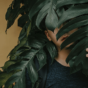 Person covered in plant leaves